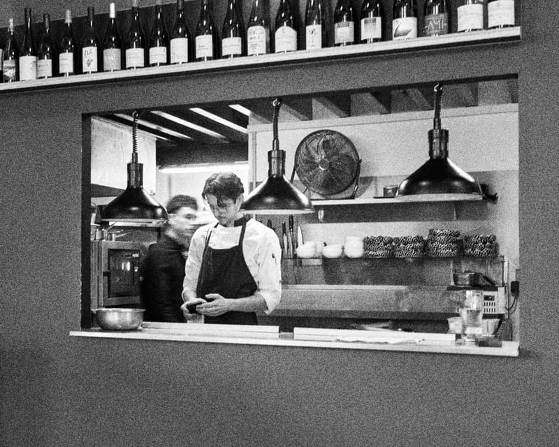 La cuisine ouverte de MUSE vue depuis la salle, en noir et blanc