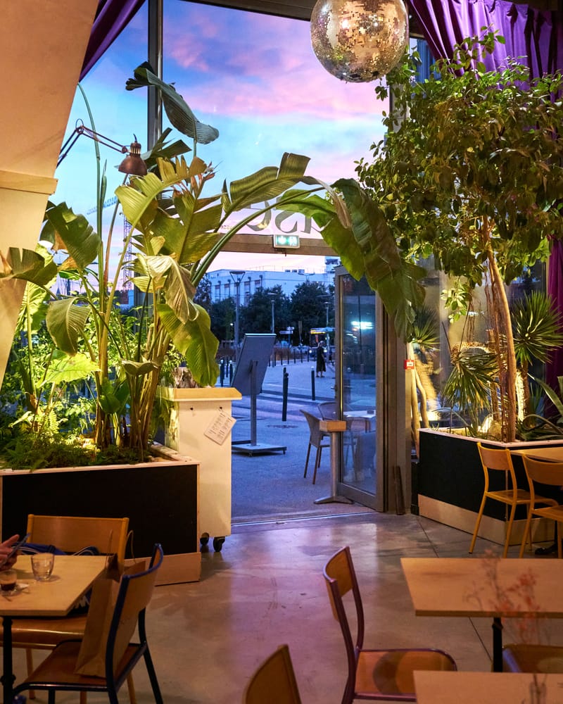 La salle de MUSE au crépuscule, plantes et baies vitrées ouvertes sur le quartier Saint-Roch